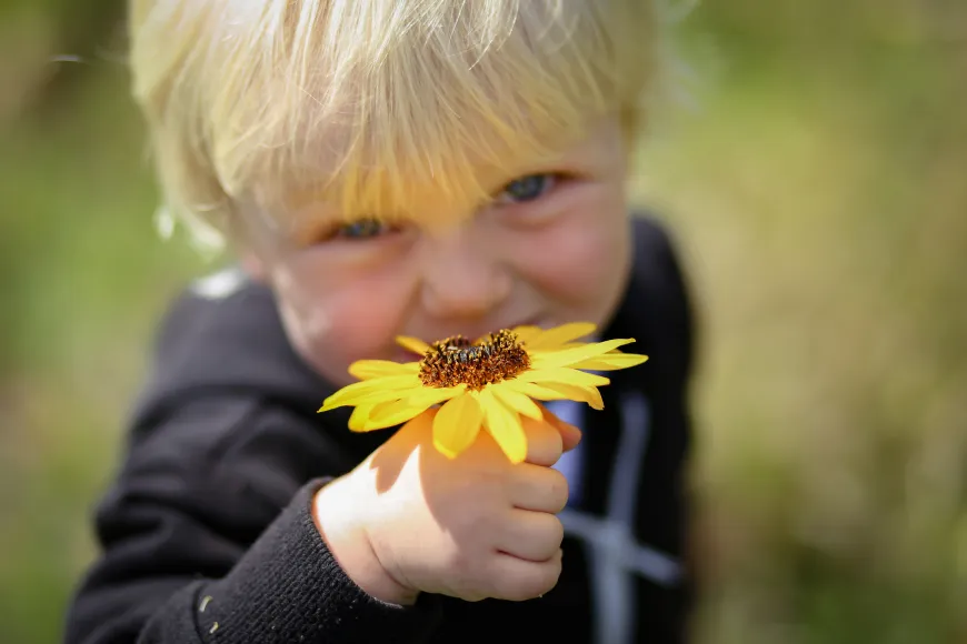 A kid holding a flower